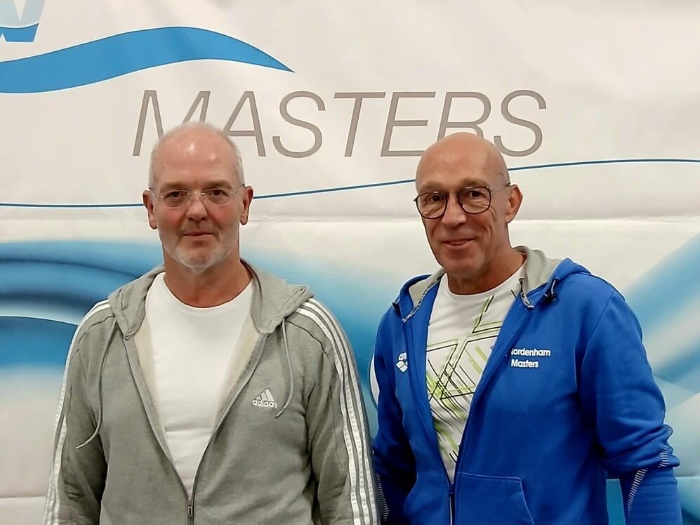 Zwei M&auml;nner stehen nebeneinander vor einem Banner der Masters.