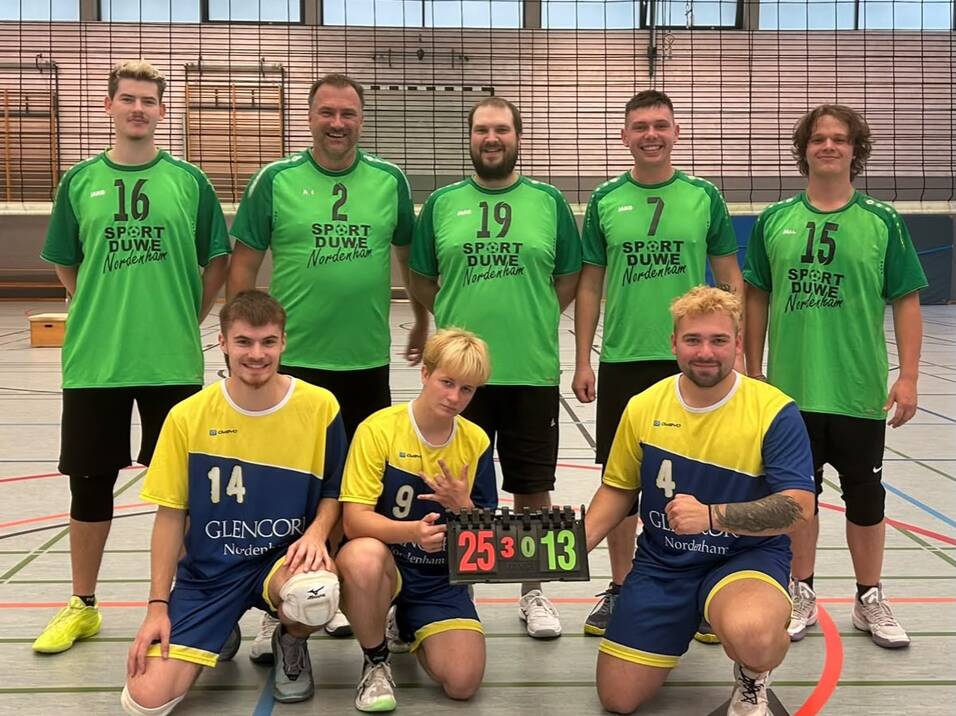 Fünf Männer in grünen Trikots und drei Männer in gelb-blauen Trikots posieren in einer Sporthalle, zwei knien und halten eine Anzeigetafel mit der Zahl '25:13'.