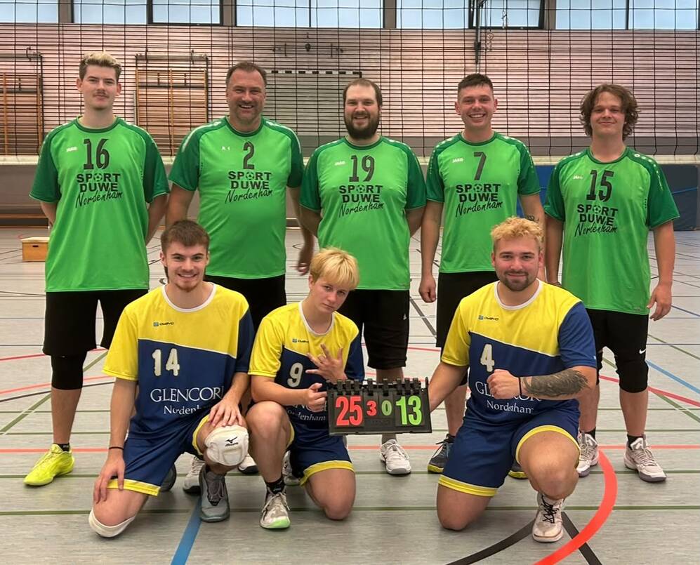 F&uuml;nf M&auml;nner in gr&uuml;nen Trikots und drei M&auml;nner in gelb-blauen Trikots posieren in einer Sporthalle, zwei knien und halten eine Anzeigetafel mit der Zahl '25:13'.