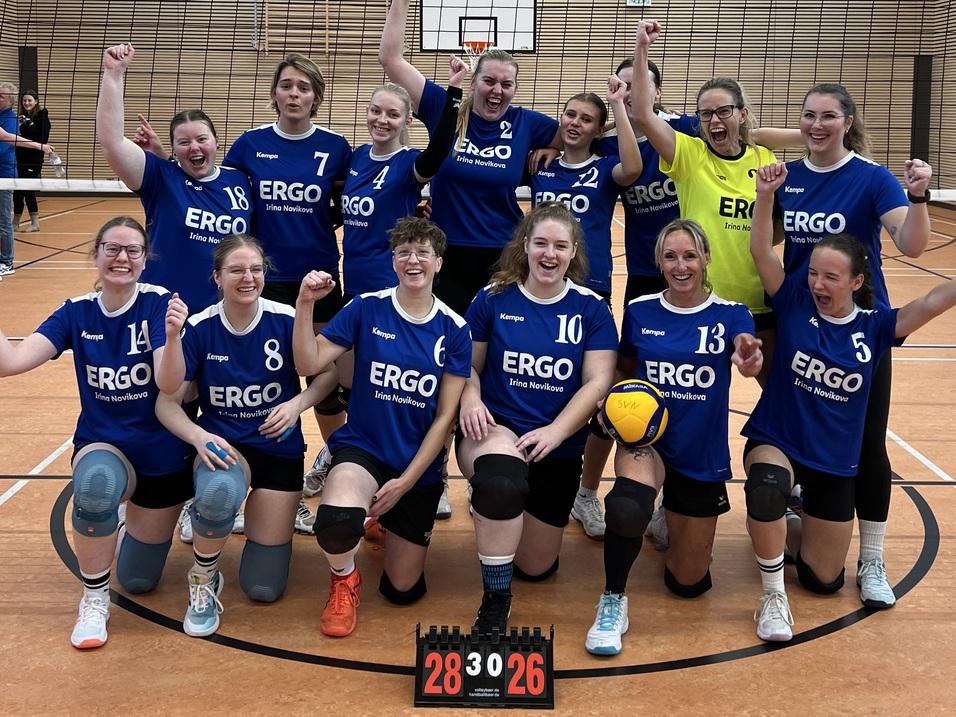 Gruppenbild des Teams der 2. Damenmannschaft, die Ihren deutlichen Sieg gegen den Bürgerfelder TB. In Ihren blauen Trikots stehen und hocken die Spielerinnen und jubeln in die Kamera.