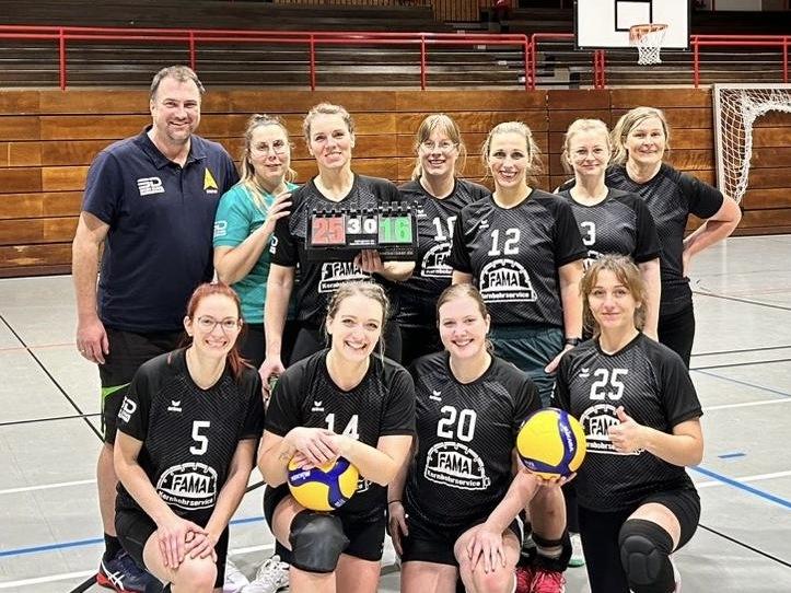Gruppenzusammenstellung von zehn Volleyballspielerinnen in schwarzen Trikots, die einen Spielstand von 25:16 präsentieren.