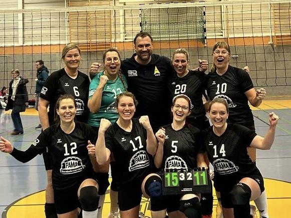 Das Volleyballteam feiert auf dem Spielfeld, mit einem Punktestand von 15, 3, 11 auf einer Anzeigetafel.