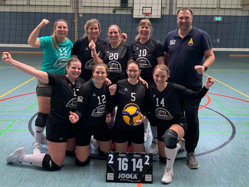Teamfoto einer Volleyballmannschaft in einer Sporthalle.