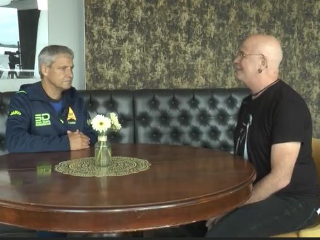 Zwei Männer sitzen an einem Tisch und führen ein Gespräch miteinander