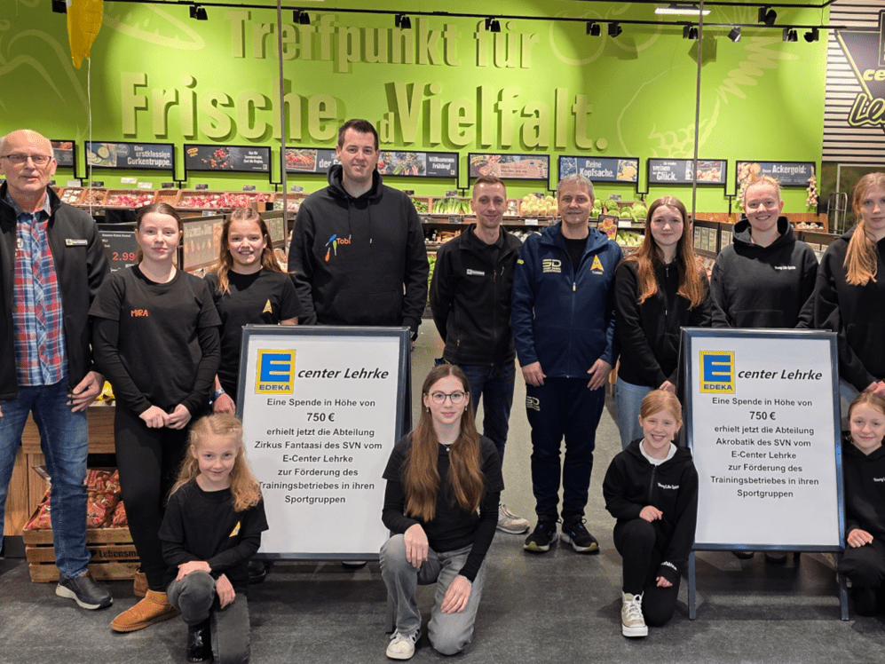 &Uuml;bergabe von zwei Schecks f&uuml;r die Nachwuchsarbeit im Sportverein. Kinder und Erwachsene auf dem Bild vor einem gr&uuml;nen Hintergrund.